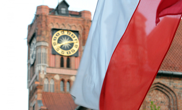 Biało-czerwona flaga, w tle wieża Ratusza Staromiejskiego