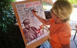 Na zdjęciu uczestniczka historycznego rajdu rowerowego podpisuje pamiątkowy plakat
