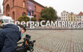 Napis EnergaCamerimage na Rynku Nowomiejski, na pierwszym planie operator kamery