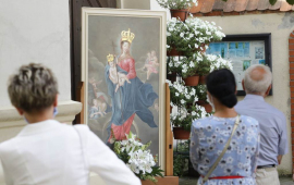 Obraz matki Boskiej Podgórskiej, przy nim modla się wierni