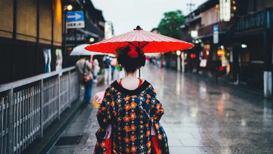 Japonka w tradycyjnym stroju, z parasolką idzie ulicą