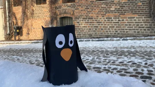 zdjęcie papierowego pingwina na śniegu