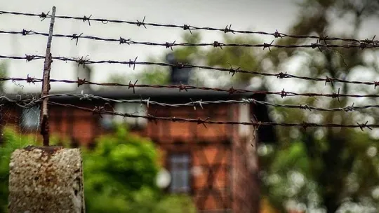 zdjęcie domu szachulcowego za kolczastym drutem
