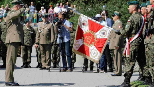 Oficer Wojska Polskiego salutuje sztandarowi Garnizonu Toruń.
