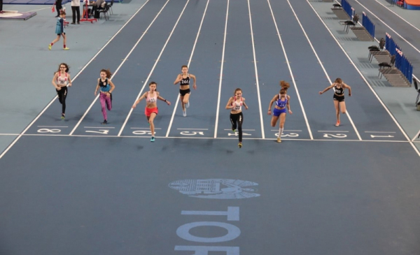 Na zdjęciu widać biegaczy na linii startu w hali