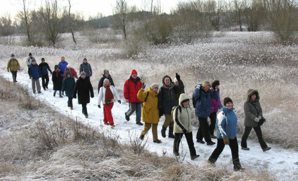 Grupa turystów wędrująca zimą w terenie poza miastem 