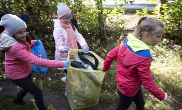 Na zdjęciu: dzieci zbierające śmieci do worka