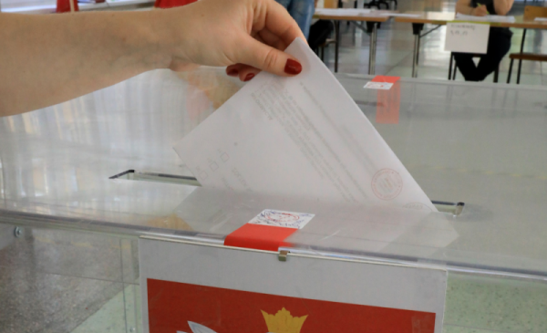 Karta wyborcza wrzucana do urny z przezroczystego tworzywa.