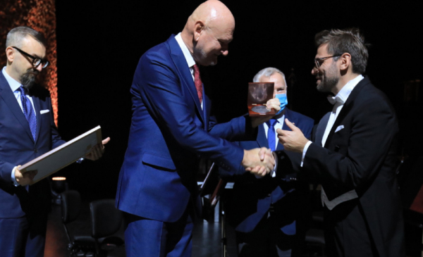 Dyrygent Przemysław Fiugajski otrzymuje medal prezydenta Thorunium