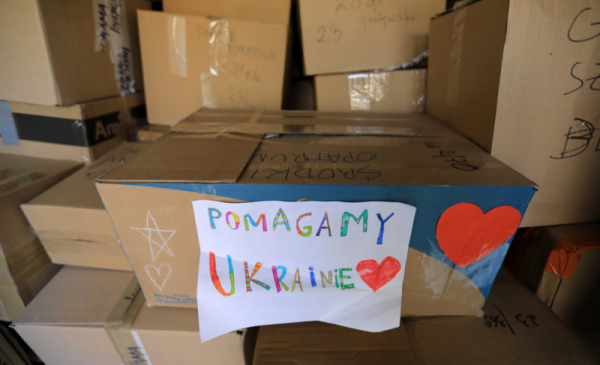 Na zdjęciu: kartony z darami, na nich kolorowy napis "Pomagamy Ukrainie"