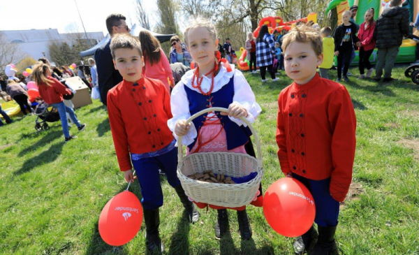 Na zdjęciu dzieci podczas pikniku, jedno ubrane w strój ukraiński