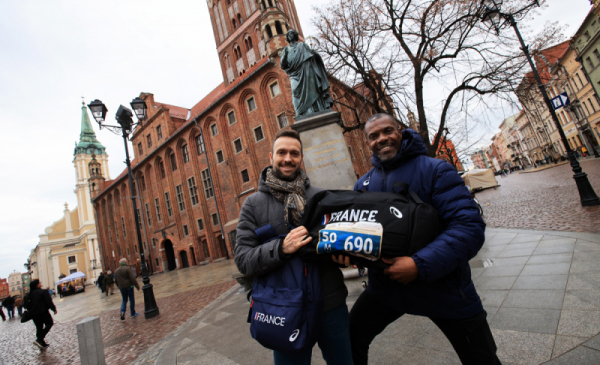 Na zdjęciu: sportowcy pokazują swoje numery startowe przy pomniku Mikołaja Kopernika