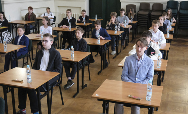 Na zdjęciu: uczestnicy etapu centralnego  Ogólnopolskiego Konkursu Wiedzy o Mikołaju Koperniku siedzą pojedynczo w ławkach szkolnych