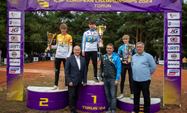 Zwycięzcy mistrzostw z medalami na podium i wiceprezydent Pietrucień
