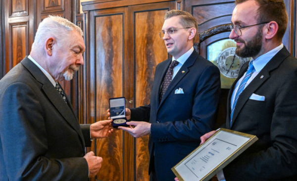 Wiceprezydent Torunia Adrian Mól wręcza medal perzydentowi Krakowa Jackowi Majchrowskiemu