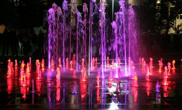 Na zdjęciu: woda tryskająca z fontanny w kolorach czerwonym i fioletowym