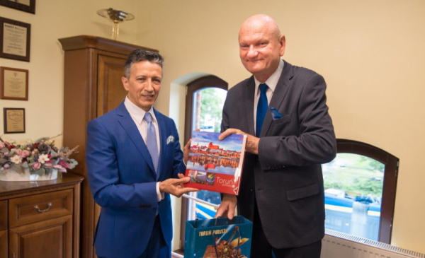 Ambasador Republiki Kolumbii oraz prezydent Michał Zaleski pokazują album o Toruniu
