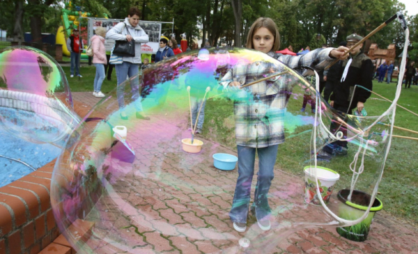 Na zdjęciu: dziewczynka robi wielkie bańki mydlane