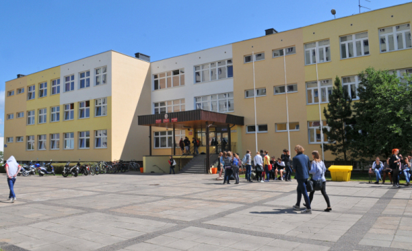 Na zdjęciu: budynek szkoły podstawowej, przed nim uczniowie