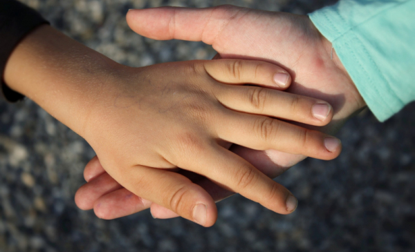 Na zdjęciu: dwie trzymające się dłonie dziecięce