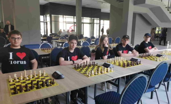 Ne zcjęciu: toruńska reprezentacja w II Szachowym Charytatywnym Turnieju Miast siedzi przy stołach, na których leżą plansze szachowe