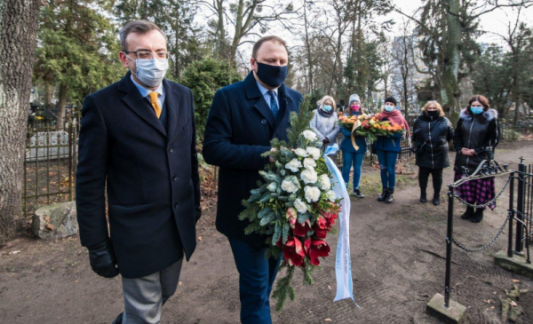 Zastępca prezydenta Paweł Gulewski i przewodniczący Rady Miasta Marcin Czyżniewski składają kwiaty na grobie Wandy Szuman, w tle widać uczniów VII LO