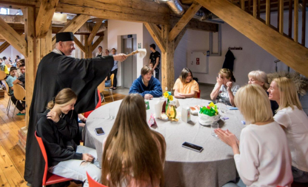 Na zdjęciu: prawosławny duchowny święci stoły i uczestnikow wielkanocnego śniadania