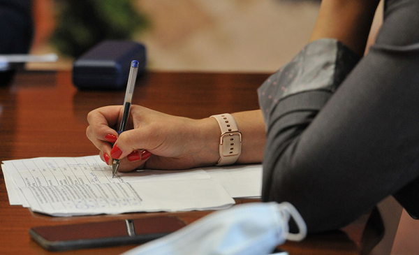 Ręka kobiety z długopisem nad dokumentem