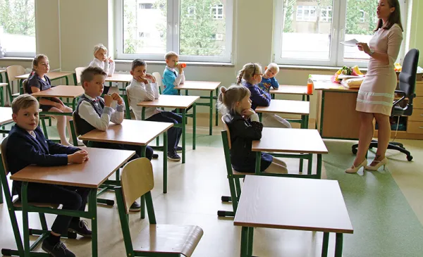 Klasa szkolna i uczniowie siedzący w ławkach.