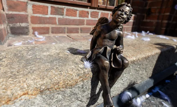 Szlak Toruńskich Aniołów - figurka anioła siedzi na murku przy Ratuszu