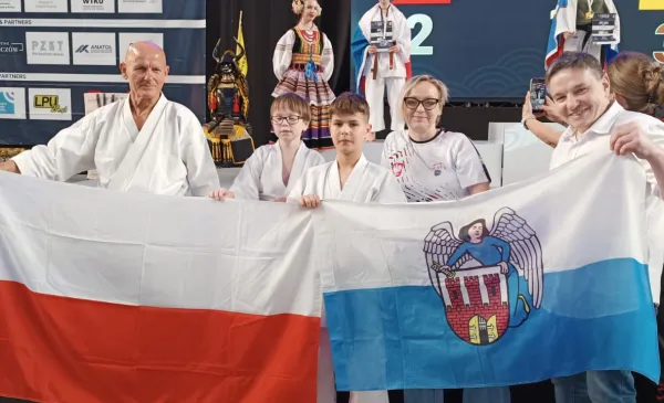 Zawodnicy AKKT Toruń z flagami Polski i Torunia