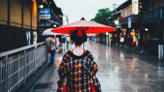 Japonka w tradycyjnym stroju, z parasolką idzie ulicą