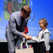 Nagrodę wręcza zastępca prezydenta Torunia Adam Szponka