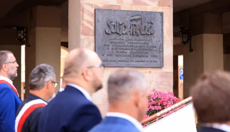 Kwiaty pod pomnikiem ks. Popiełuszki i tablicą Solidarności