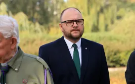 Kwiaty pod pomnikiem ks. Popiełuszki i tablicą Solidarności