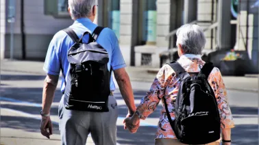 Para seniorów spaceruje po Toruniu trzymając się za ręce.