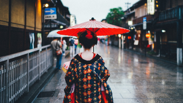 Japonka w tradycyjnym stroju, z parasolką idzie ulicą