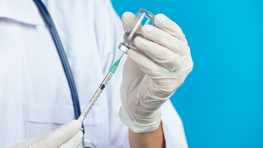 zdjęcie dłoni trzymających strzykawkę ze szczepionką