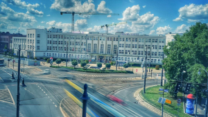 Na zdjęciu: widok na ulicę, pośrodku której biegnie linia tramwajowa, w tle duży biały budynek urzędu marszałkowskiefo