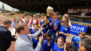 Na zdjęciu: zastępca prezydenta Adam Szponka wręcza puchar drużynie dzieci w niebieskich koszulkach
