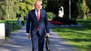 Na zdjęciu: ubrany w garnitur prezydent Michał Zaleski, trzyma w ręce teczkę i idzie chodnikiem wzdłuż zieleni