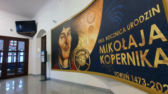 Baner 550-lecia Mikołaja Kopernika przed wejściem do sali sesyjnej Rady Miasta Torunia