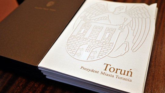 Na zdjęciu: teczka z herbem Torunia, w której znajduje się decyzja o przyznaniu stypendium