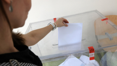 Na zdjęciu: ręka kobiety wrzuca kartę do urny wyborczej