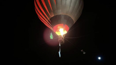Na zdjęciu: balon unoszący się na tle ciemnego nieba