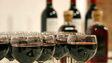 Na zdjęciu: kieliszki z winem, w tle butelki
