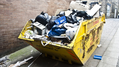 Na zdjęciu: żółty kontener wypełniony śmieciami