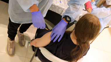 Na zdjęciu młoda osoba szczepiąca się przeciw Covid-19