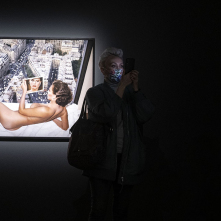 Na zdjęciu uczestniczka wydarzenia fotografuje prace Helmuta Newtona, w tle dzieło Gunilla Bergström over Paris