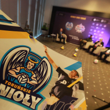 Na pierwszym planie logo nowego klubu Toruńskie Anioły, w tle trwa spotkanie z Wilfredo Leonem Wenero